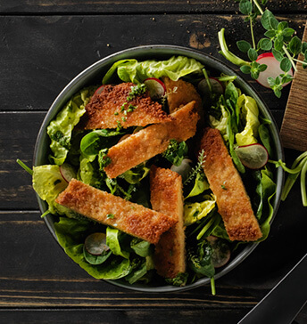 Vegane Schnitzelstreifen auf grünem Salat